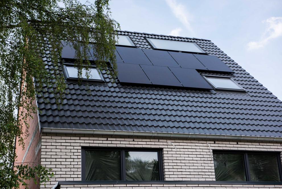 Ein Haus auf dessen Dach Solarpanel angebracht sind.