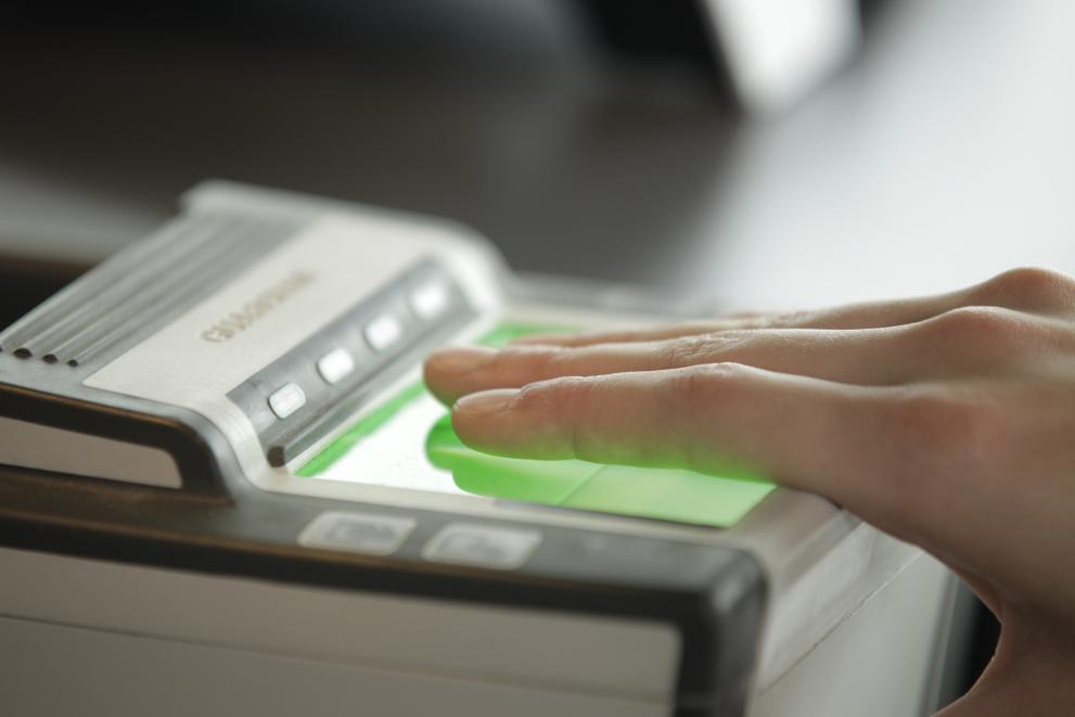 Eine Person scannt ihre Finger auf einem Hand-Scanner