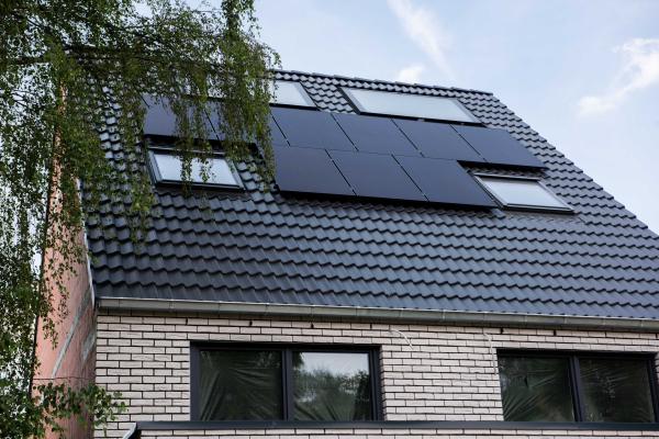 Ein Haus auf dessen Dach Solarpanel angebracht sind.